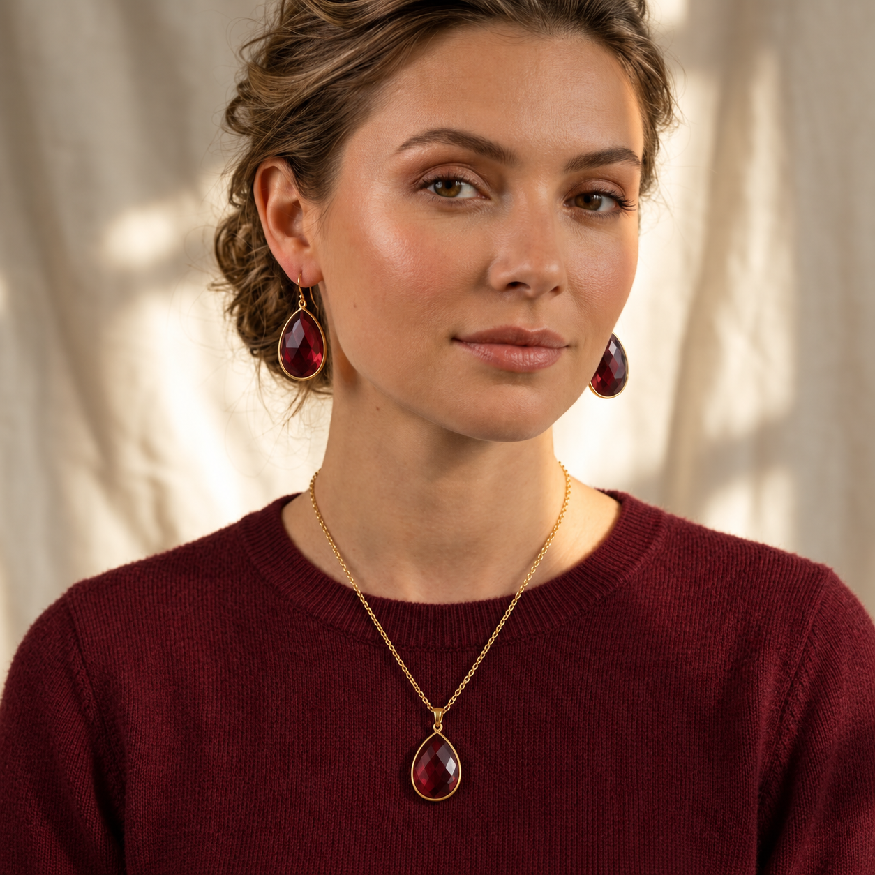 Woman wearing garnet teardrop earrings with matching January birthstone necklace
