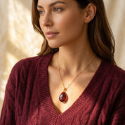 Model wearing garnet teardrop necklace in gold, deep red January birthstone pendant necklace gift for her