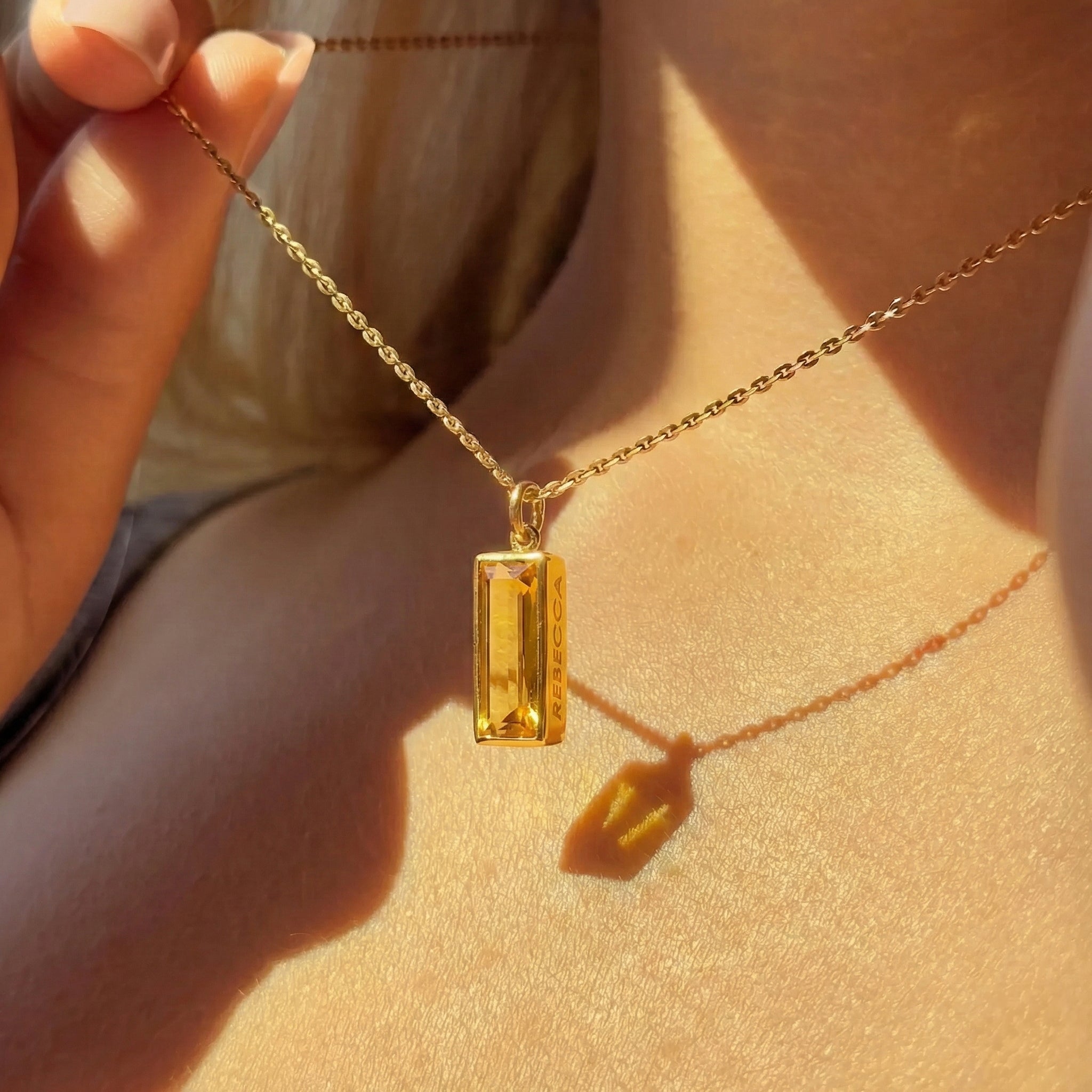 Dainty citrine bar necklace with hidden engraving worn on neck, November birthstone pendant for women