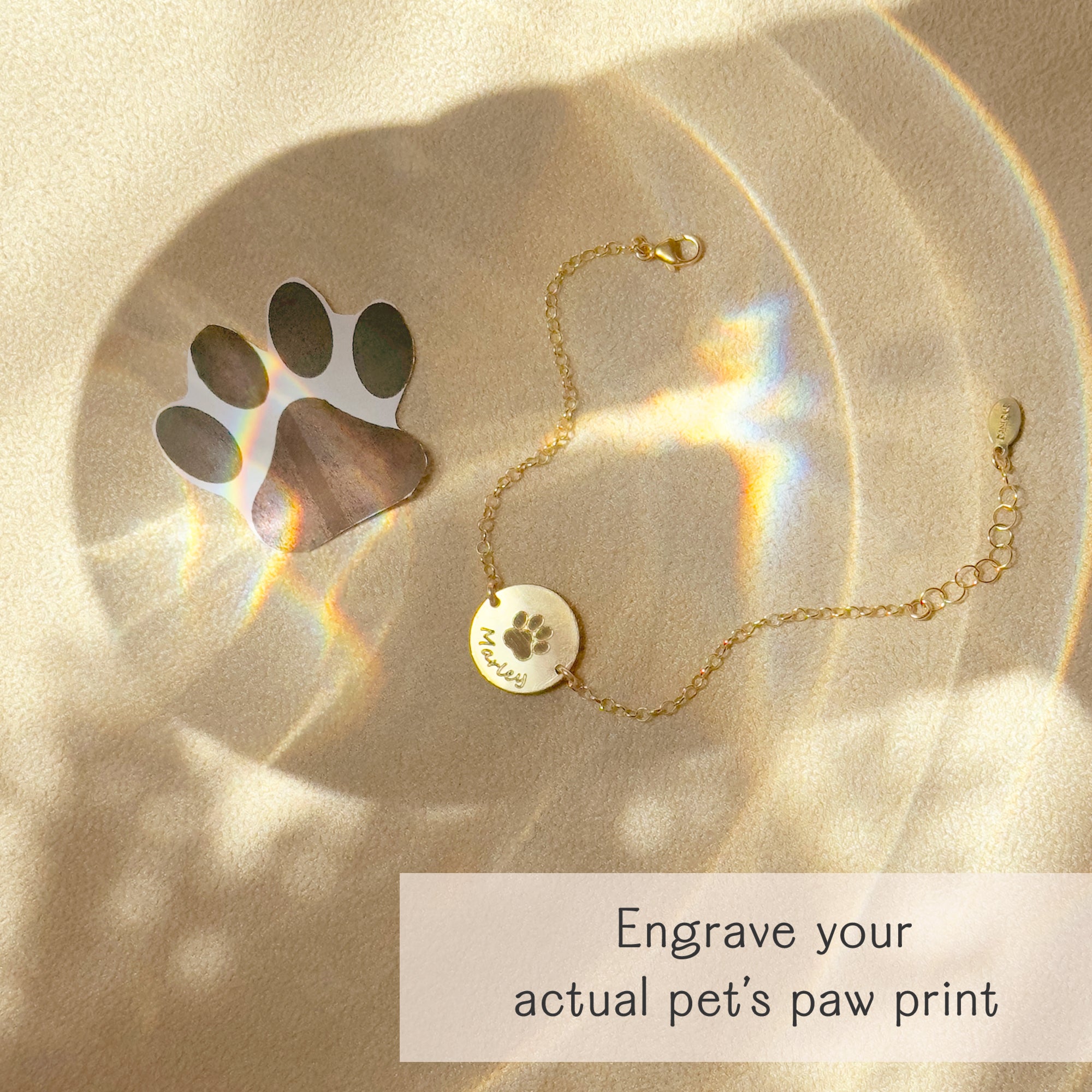 Gold bracelet engraved with an actual paw print from a pet photo, custom pet memorial jewelry with engraved name and adjustable fit option.