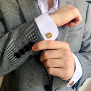 A man wearing a striped suit and gold monogrammed cufflinks. mens anniversary gifts, gifts for men, christmas gifts for him, valentine's day gifts for men, gift for husband, gift for fiance, father's day gift, birthday gift, wedding anniversary gift, wedding party gift, father of the groom gift, father of the bride gift, gift for grandfather, gift for grandpa, groomsman gift, groomsmen gift