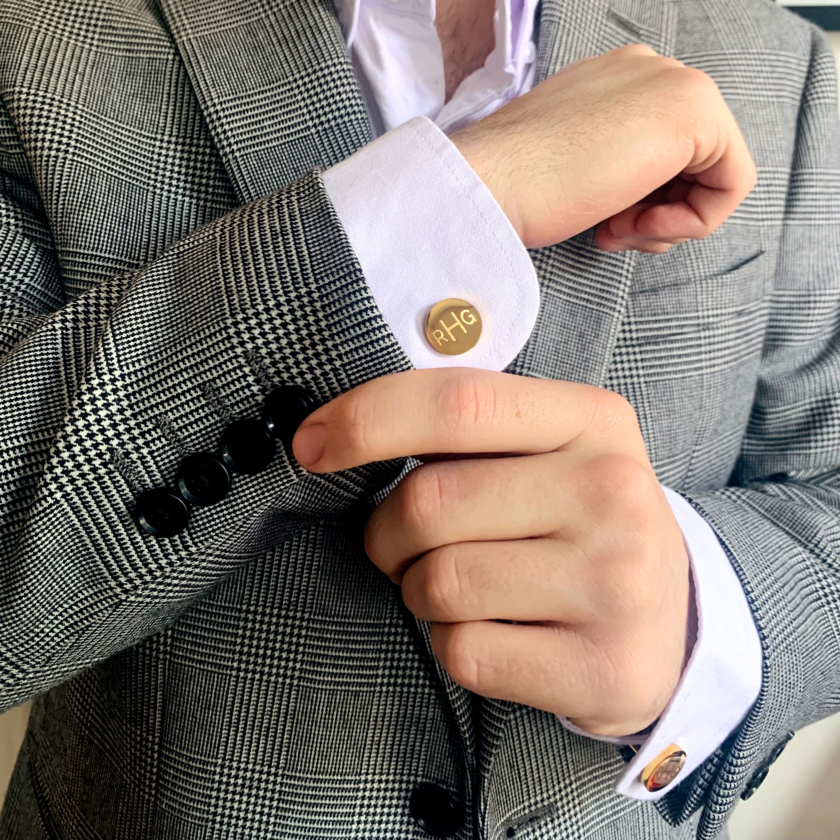 A man wearing a striped suit and gold monogrammed cufflinks. mens anniversary gifts, gifts for men, christmas gifts for him, valentine's day gifts for men, gift for husband, gift for fiance, father's day gift, birthday gift, wedding anniversary gift, wedding party gift, father of the groom gift, father of the bride gift, gift for grandfather, gift for grandpa, groomsman gift, groomsmen gift