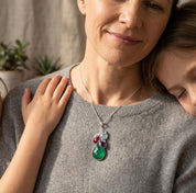 Woman wearing a personalized birthstone necklace with layered gemstone charms, a meaningful custom necklace representing children, grandchildren, or family members.