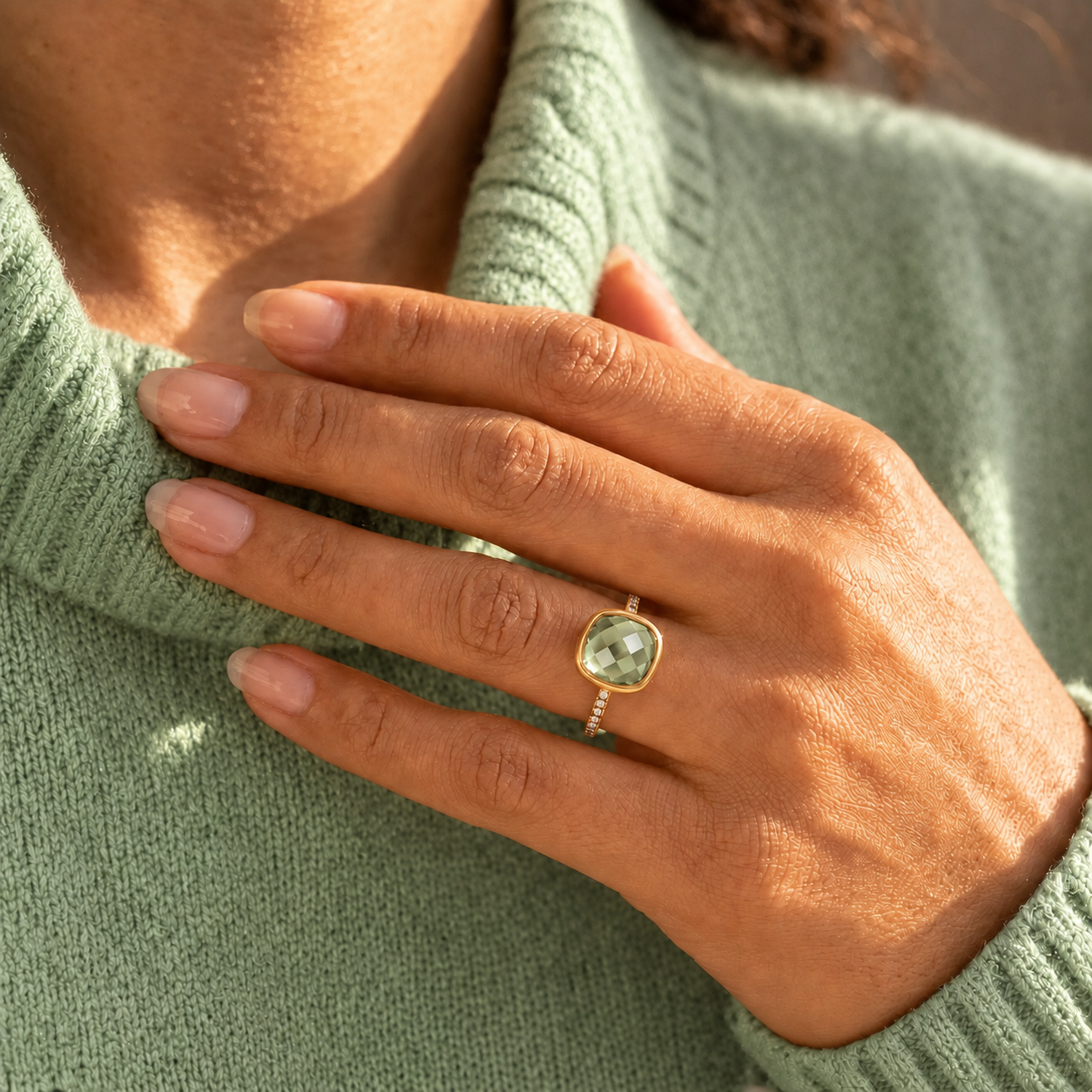 Woman wearing green amethyst cushion ring in yellow gold
