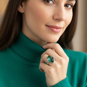 Green tourmaline statement ring worn on hand in yellow gold setting, elegant oval gemstone ring for women, October birthstone fine jewelry, modern minimalist fashion ring