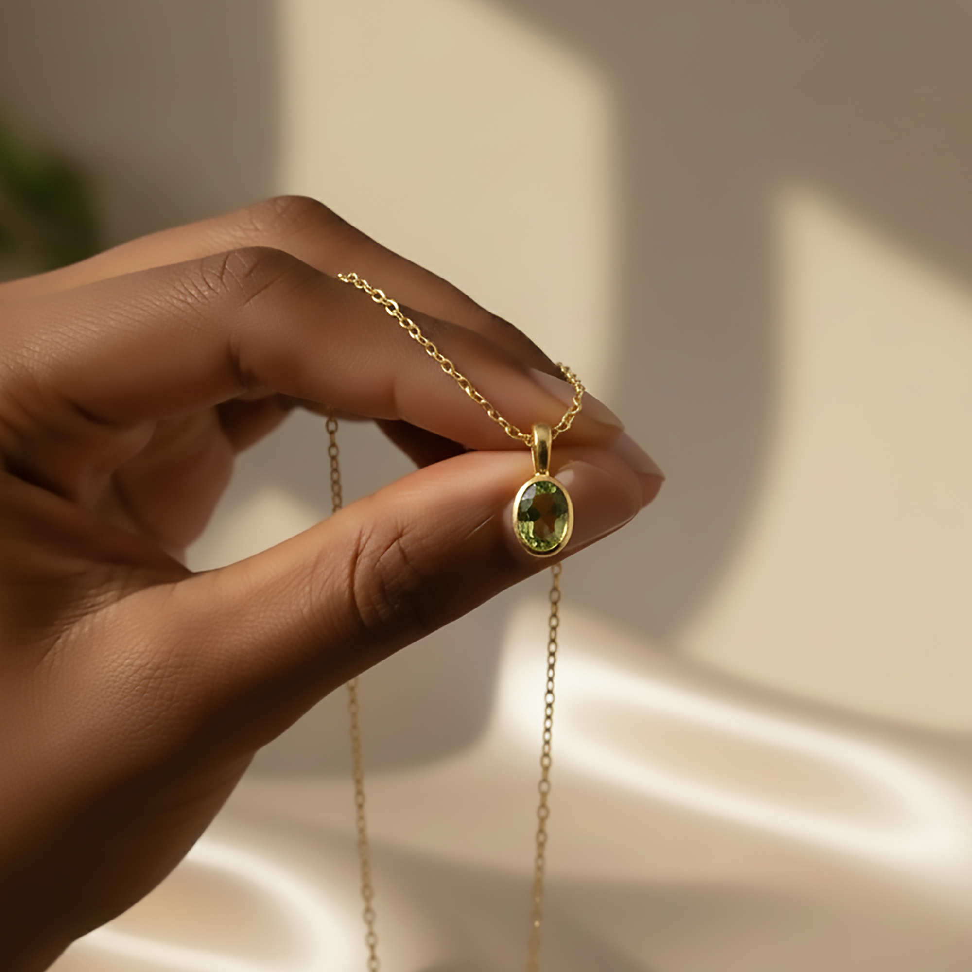 Close-up of hand holding an oval cut August Peridot birthstone bezel pendant necklace with a gold chain, highlighting the gemstone clarity and refined setting. Custom birthstone necklace designed in a minimalist style, ideal for layering. Personalized gemstone jewelry gift for her, suitable for Valentine’s Day, birthdays, or sentimental keepsake gifting.