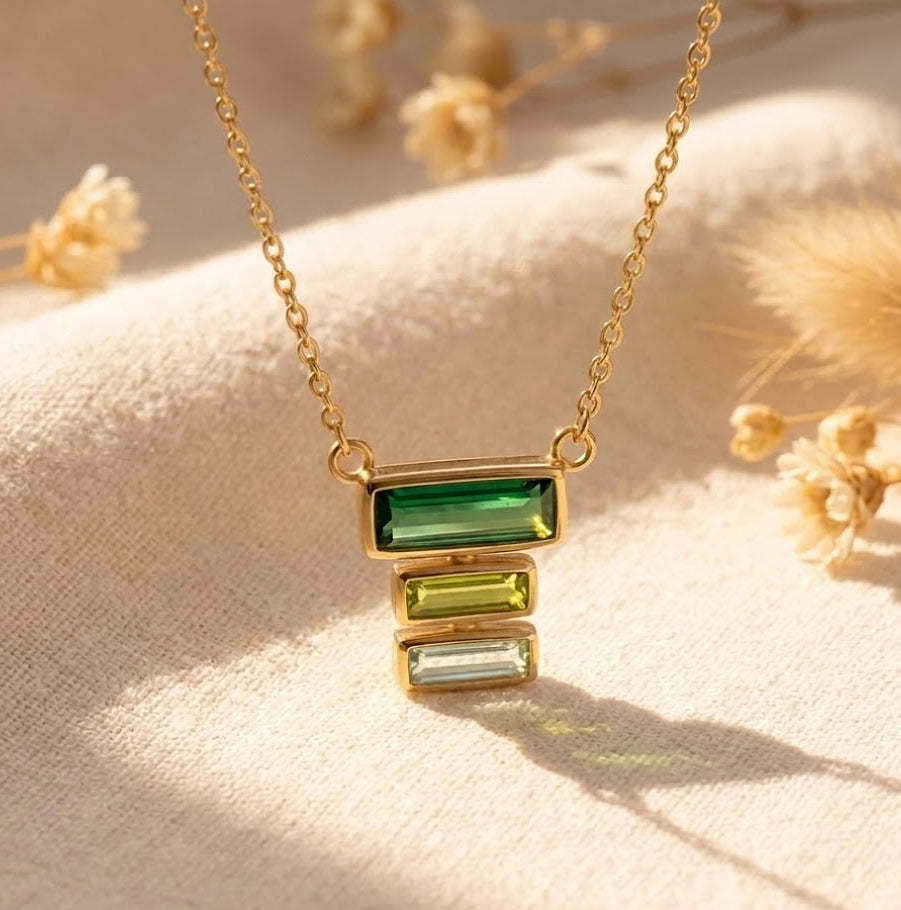 Custom birthstone mom necklace with stacked baguette gemstones representing mom and children on a delicate gold chain.