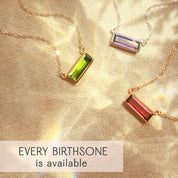 Custom birthstone bar necklaces displayed with peridot, amethyst, and ruby gemstones in sterling silver and gold filled settings, highlighting dainty bezel-set bar pendants with optional name engraving. Perfect personalized jewelry gift for mom, daughter, bridesmaid sets, birthdays, or anniversary gifting. Minimalist handcrafted gemstone necklaces from the Adira collection with every birthstone available and elegant fine chain design.