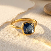 Cushion kyanite ring on light background with silver band and checkerboard faceting