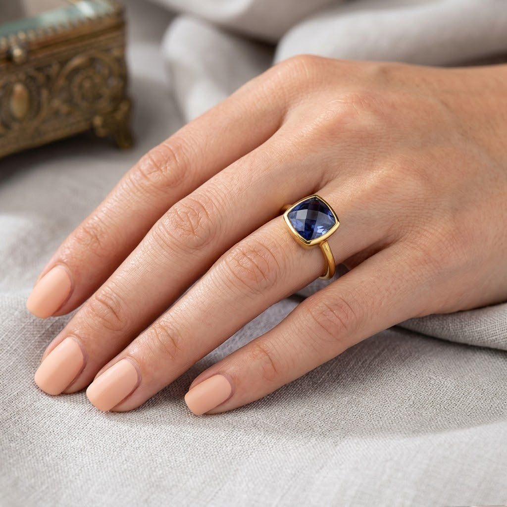Model wearing cushion kyanite ring with bold blue gemstone on silver band