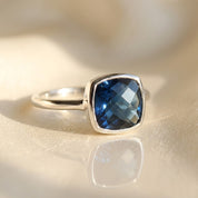 Cushion kyanite ring in sterling silver bezel setting with faceted deep blue gemstone