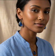 Model wearing blue kyanite earrings in gold, dainty September birthstone dangle earrings for everyday wear