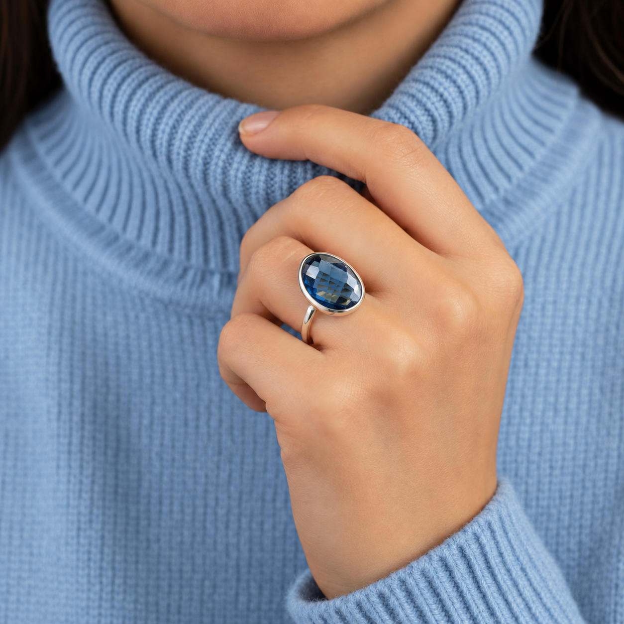 Woman wearing a large Kyanite September birthstone ring in sterling silver with a blue sweater.
