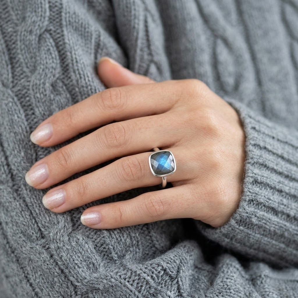 Labradorite statement ring worn on hand with gold band and glowing blue fire stone