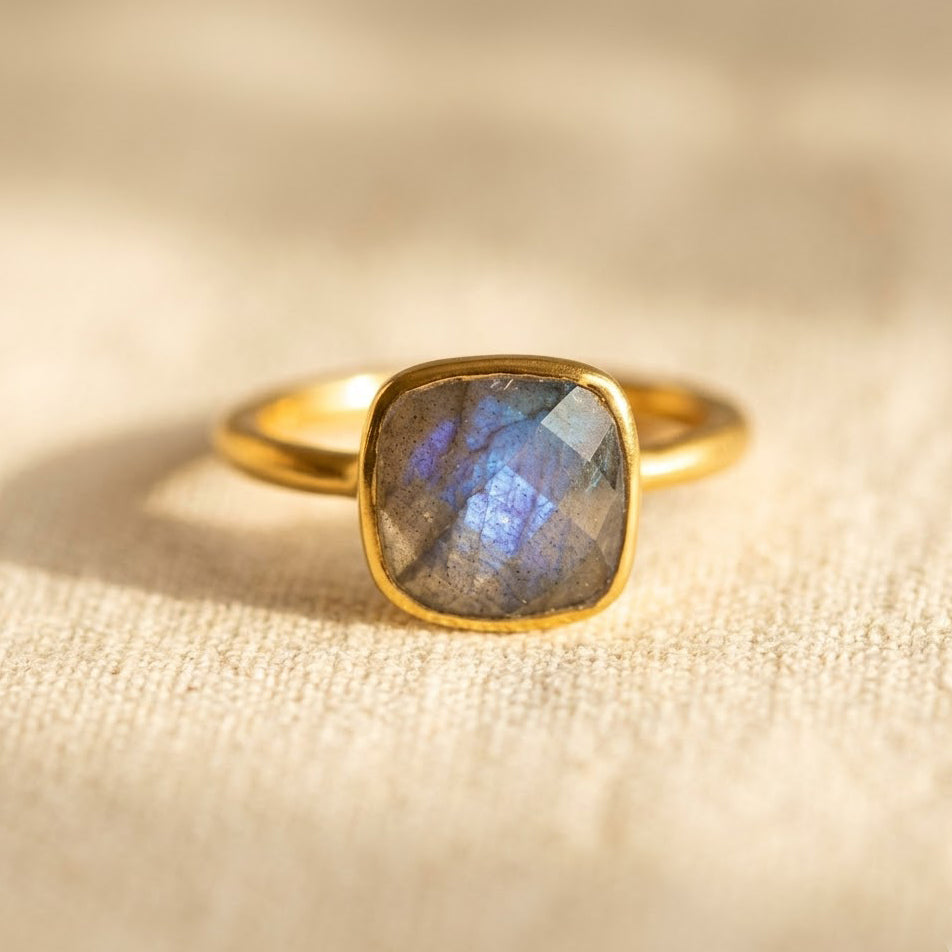 Cushion cut labradorite ring in gold bezel setting with iridescent blue flash gemstone