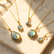 Natural labradorite necklaces in large and small round and teardrop pendant styles on silver, yellow gold, and rose gold chains.