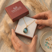 Teardrop labradorite pendant necklace presented in a burgundy Danique Jewelry gift box.