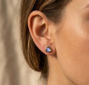 Model wearing labradorite triangle stud earrings, showing petite gemstone stud scale and minimalist everyday style.