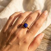 Lapis lazuli bezel set ring on fabric background, square cushion gemstone ring in gold vermeil with rich blue color