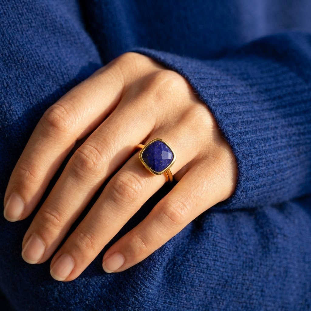 Close up of lapis lazuli ring with cushion cut gemstone, gold bezel set ring with rich blue stone and natural gold flecks