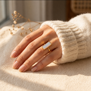 Woman wearing an Opalite rectangular bar ring with a cream sweater in warm natural light.
I