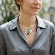 Woman wearing Ocean Breeze Sculptural Halo pendant necklace with gray satin blouse

