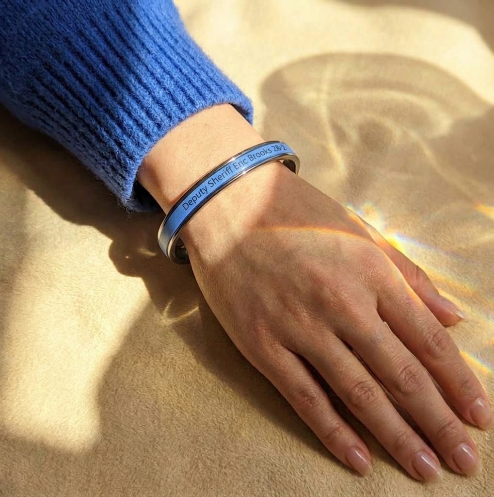 Custom engraved blue leather cuff bracelet worn on wrist
