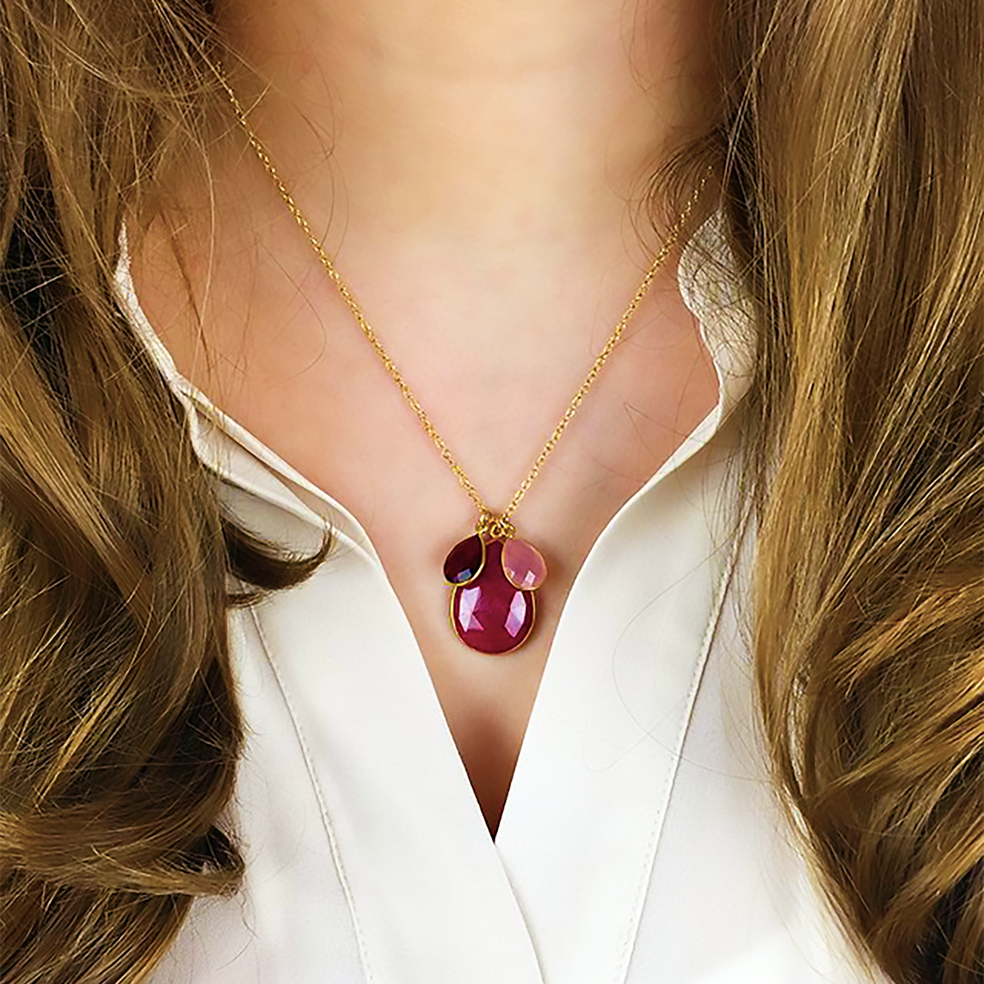 Model in white top is wearing a gold filled cable chain with mother's ruby birthstone and garnet and pink chalcedony kids birthstones. 