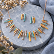 Boho Sunray fringe necklace and matching stud earrings with turquoise gold silver and rose gold bars on gray stone

