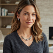 Woman wearing colorful mixed metal Sunray statement necklace with charcoal gray top

