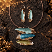 Boho triple barrette necklace and aqua drop earrings displayed on dark textured stone

