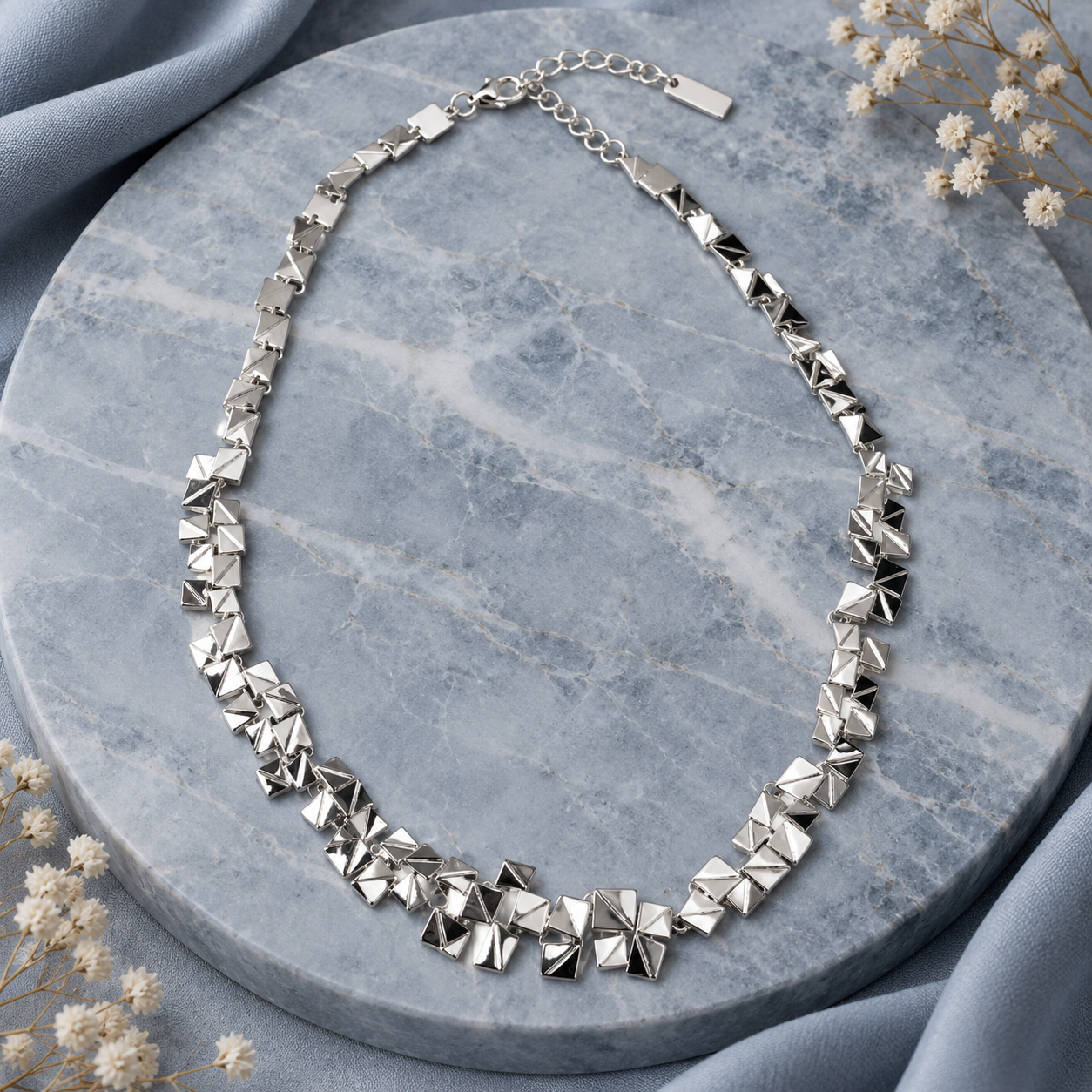 Full Silver geometric pyramid necklace displayed on gray stone with adjustable chain
