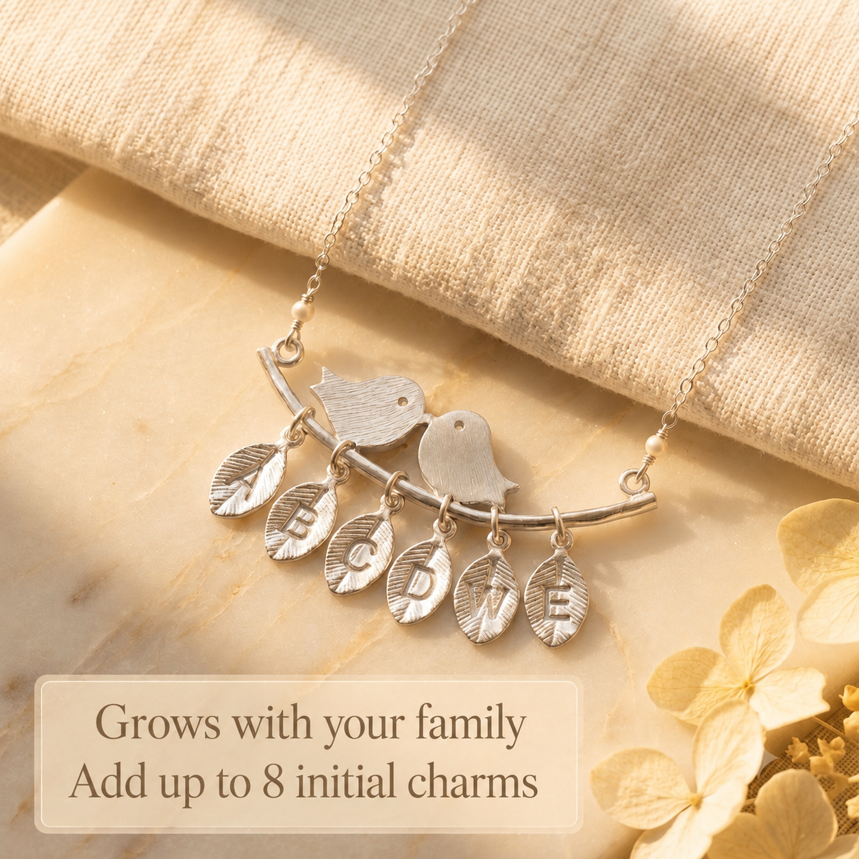 Silver lovebirds necklace with multiple dangling charms designed to grow with a family.