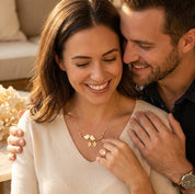 Smiling couple admiring a gold personalized lovebirds necklace with meaningful initial charms.