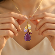 Mom wearing personalized family necklace with large purple birthstone, kids birthstones and engraved name charms