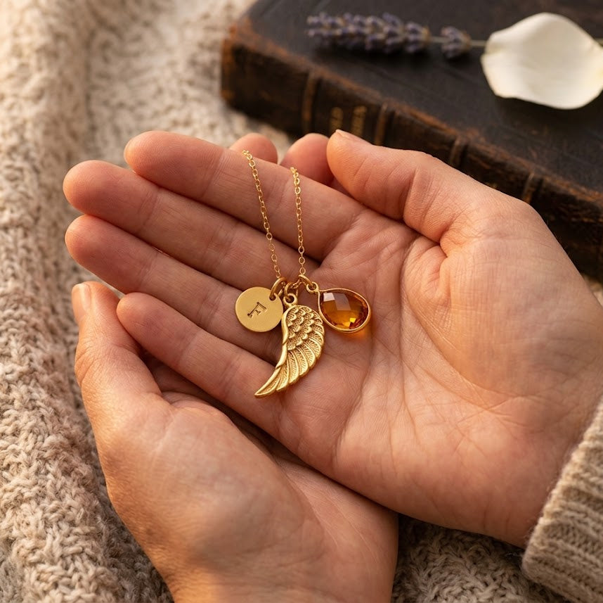 Close up of custom angel wing necklace with birthstone and engraved initial