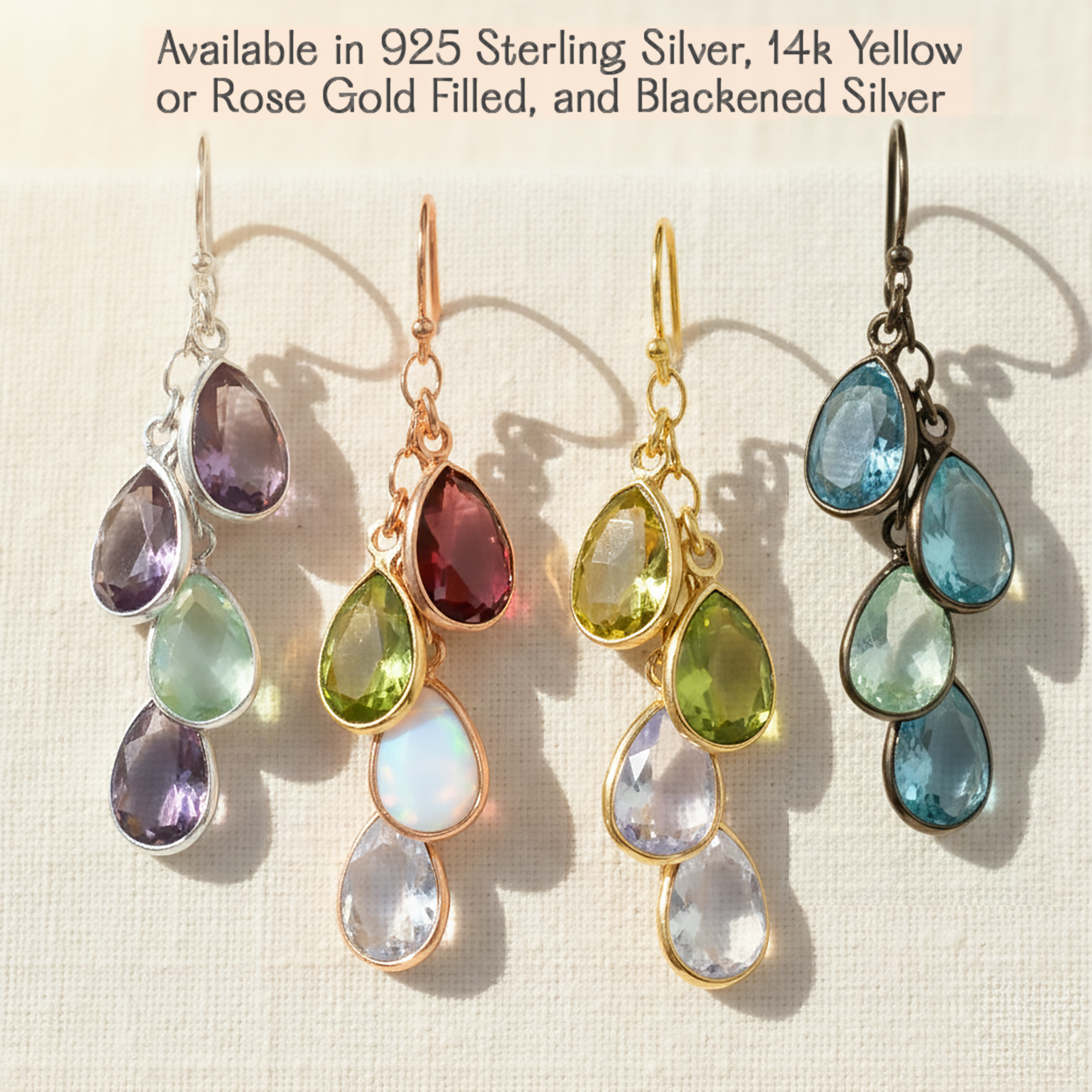 Set of four pairs of teardrop-shaped gemstone earrings in various metals on a light background.Custom birthstone earrings for grandma with hand-set teardrop gemstones arranged in a delicate drop style, representing grandchildren in a timeless and elegant design handcrafted in Massachusetts.