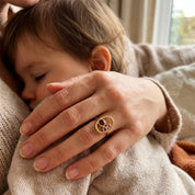 mother and baby wearing custom birthstone ring for mom, meaningful family jewelry with children birthstones january garnet february amethyst march aquamarine