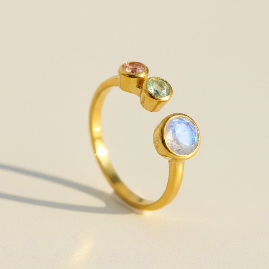 A multi birthstone ring for mom of two featuring one large 5mm bezel-set birthstone and two small 3mm child stones on an adjustable open band in gold vermeil. This custom family ring is designed as a meaningful gift for mom, perfect for celebrating children, birthdays, Mother’s Day, or a new baby. The dainty personalized bezel-set gemstone arrangement highlights your family story in elegant handmade jewelry she can wear every day.