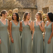 Bridesmaids wearing matching monogram disc necklaces, showing personalized gold pendant jewelry as bridal party gifts.