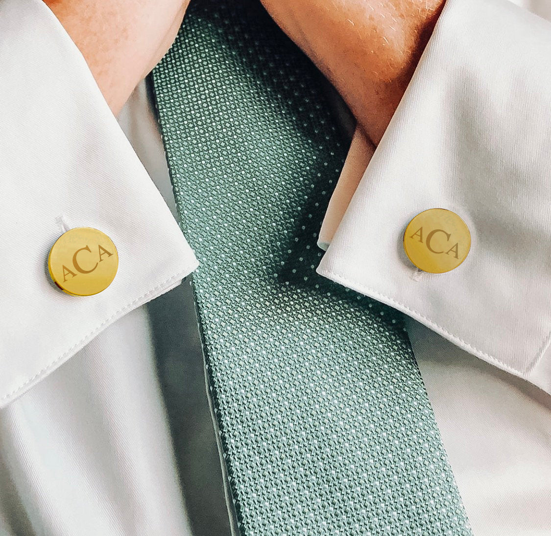A man in a white dress shirt wearing monogrammed gold round cuff links. mens anniversary gifts, gifts for men, christmas gifts for him, valentine's day gifts for men, gift for husband, gift for fiance, father's day gift, birthday gift, wedding anniversary gift, wedding party gift, father of the groom gift, father of the bride gift, gift for grandfather, gift for grandpa, groomsman gift, groomsmen gift