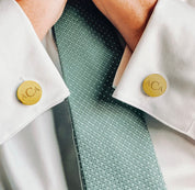 A man in a white dress shirt wearing monogrammed gold round cuff links. mens anniversary gifts, gifts for men, christmas gifts for him, valentine's day gifts for men, gift for husband, gift for fiance, father's day gift, birthday gift, wedding anniversary gift, wedding party gift, father of the groom gift, father of the bride gift, gift for grandfather, gift for grandpa, groomsman gift, groomsmen gift