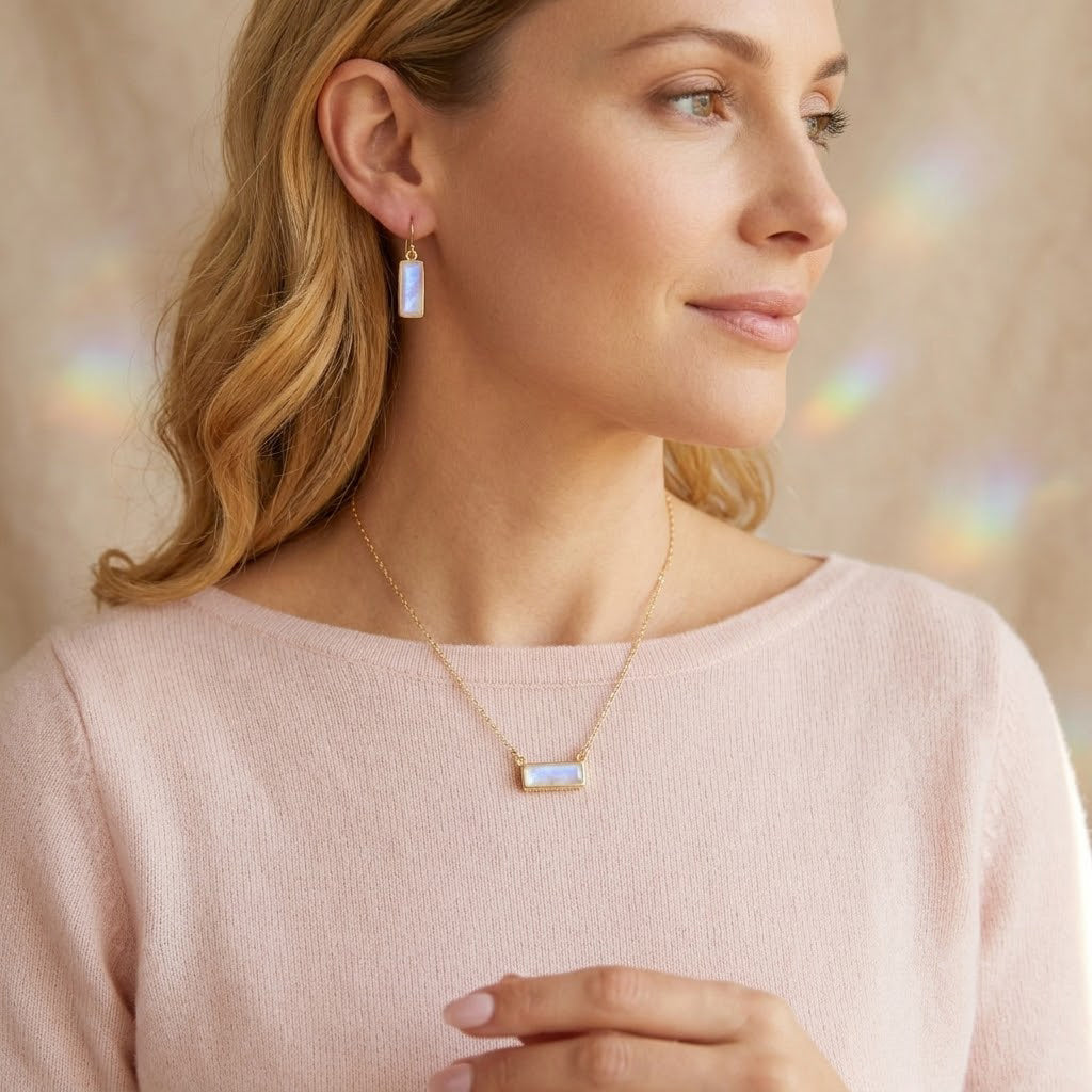 Model wearing a moonstone bar necklace with matching moonstone earrings, styled as elegant June birthstone jewelry.