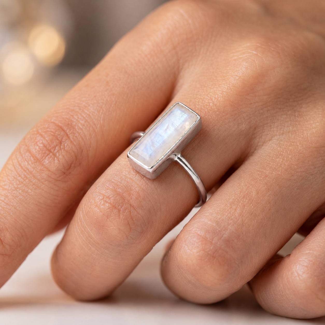 Sterling silver moonstone bar ring worn on a hand, showing the small rectangular gemstone ring style.