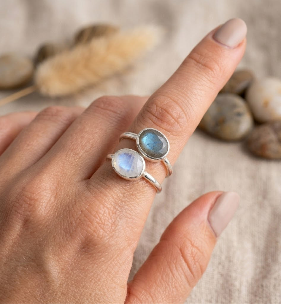 Sterling-silver moonstone and labradorite oval bezel rings worn as a coordinated stack.