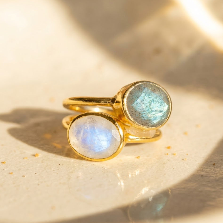 Gold-vermeil labradorite and rainbow moonstone oval stacking ring set in warm natural sunlight.