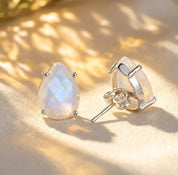 Rainbow moonstone teardrop stud earrings shown in sterling silver, featuring natural iridescent gemstones with a soft luminous glow.