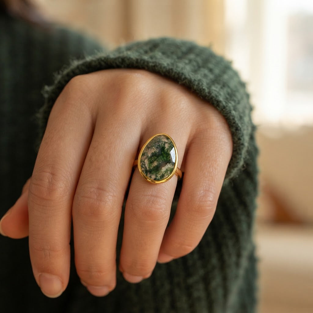 Natural moss agate statement ring worn on woman's hand with large faceted green teardrop gemstone in gold vermeil