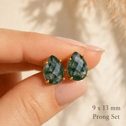 9 x 13 mm natural moss agate teardrop prong set stud earrings held between fingers