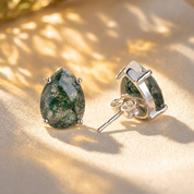 Natural moss agate teardrop stud earrings in sterling silver showing front prong setting and post back